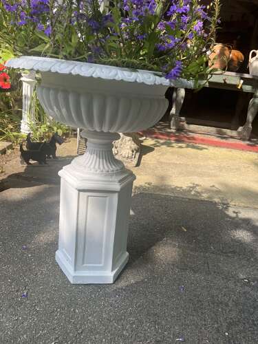 Pair of white painted cast iron garden urns on pedestals