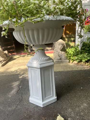 Pair of white painted cast iron garden urns on pedestals