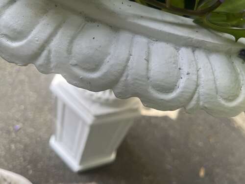 Pair of white painted cast iron garden urns on pedestals